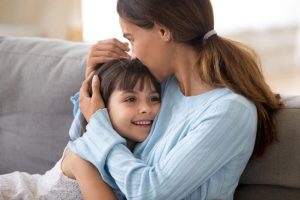 mom hugging smiling daughter